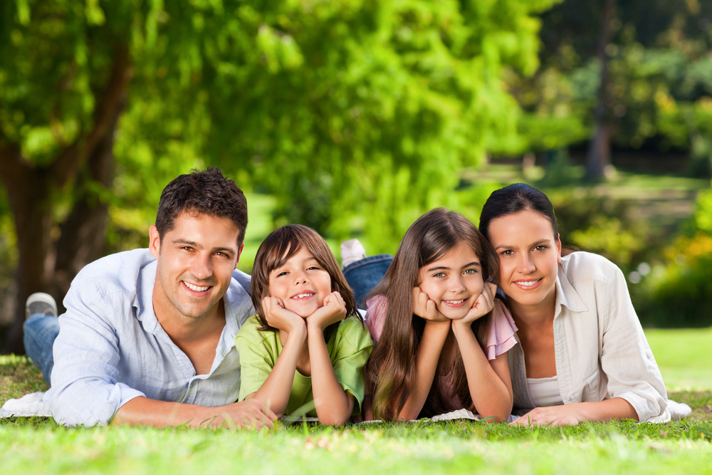 Family Relaxing in the Park: Hampton Kecoughtan Community Family of four lying together in the grass at a park near Hampton Kecoughtan