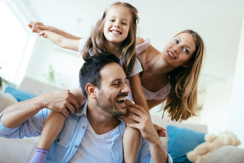 Family Having Fun at Home: Hampton Kecoughtan Patients Happy family laughing together at home, patients of The Foleck Center in Hampton Kecoughtan