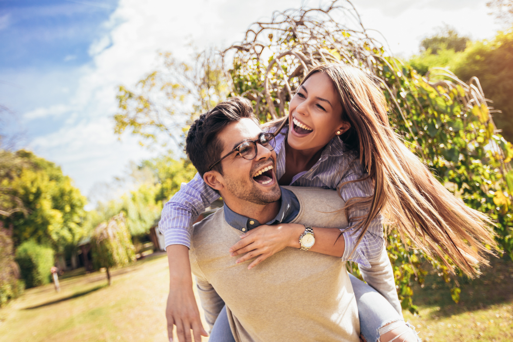 Confident, happy smiles: dental care in the Norfolk community Couple laughing together outdoors, reflecting the confident smiles patients enjoy in the Norfolk community