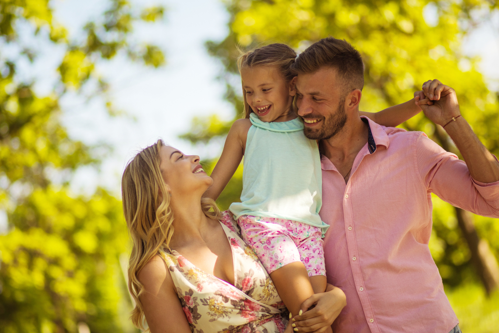 Happy family enjoying time outdoors together after gum disease treatment in Norfolk 