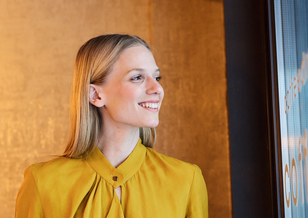 Portrait of a young businesswoman woman posing in front of a wall in the office