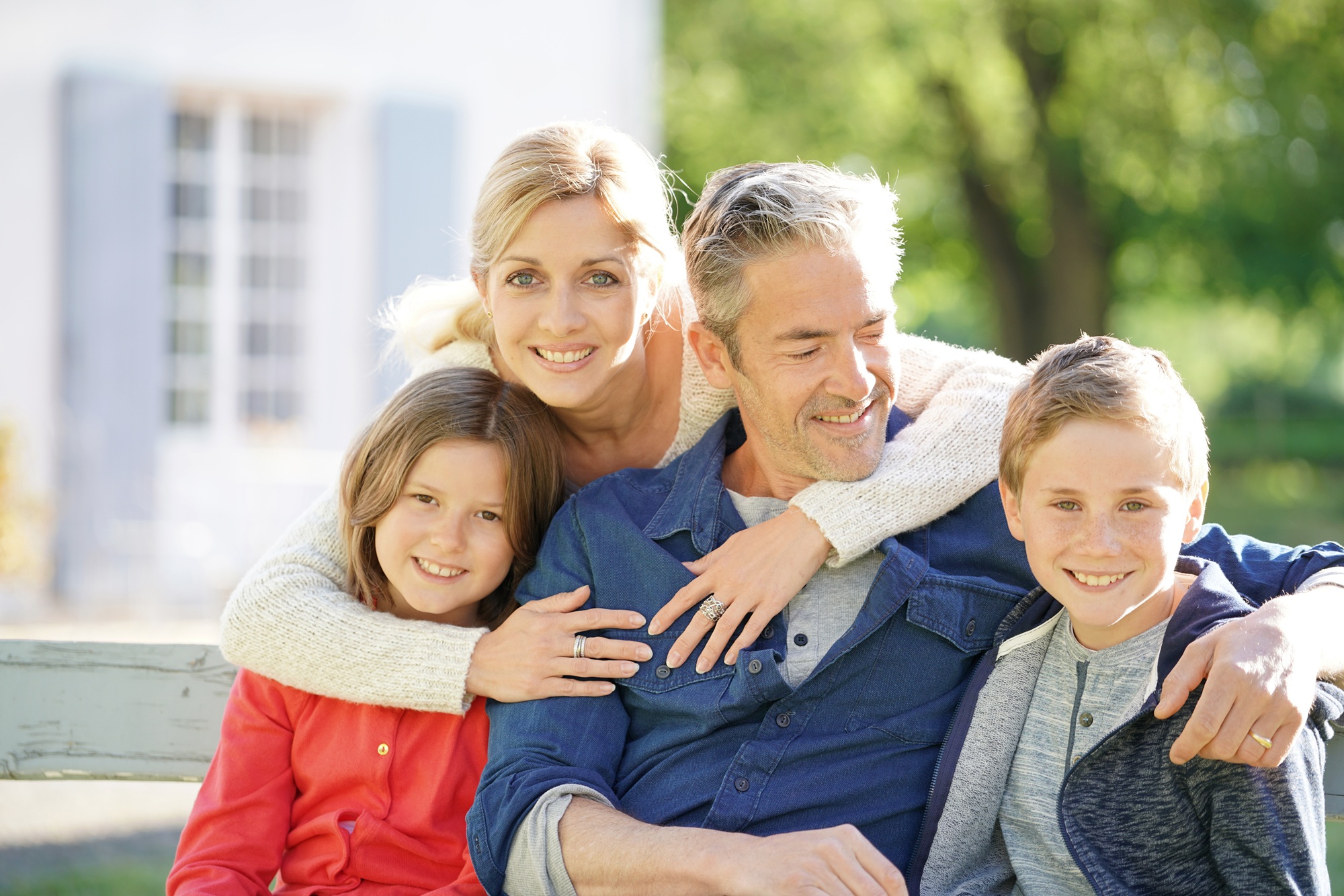 Family Portrait After Dental Fillings: Norfolk Community Family of four smiling together outside their home after dental filling treatment in the Norfolk community