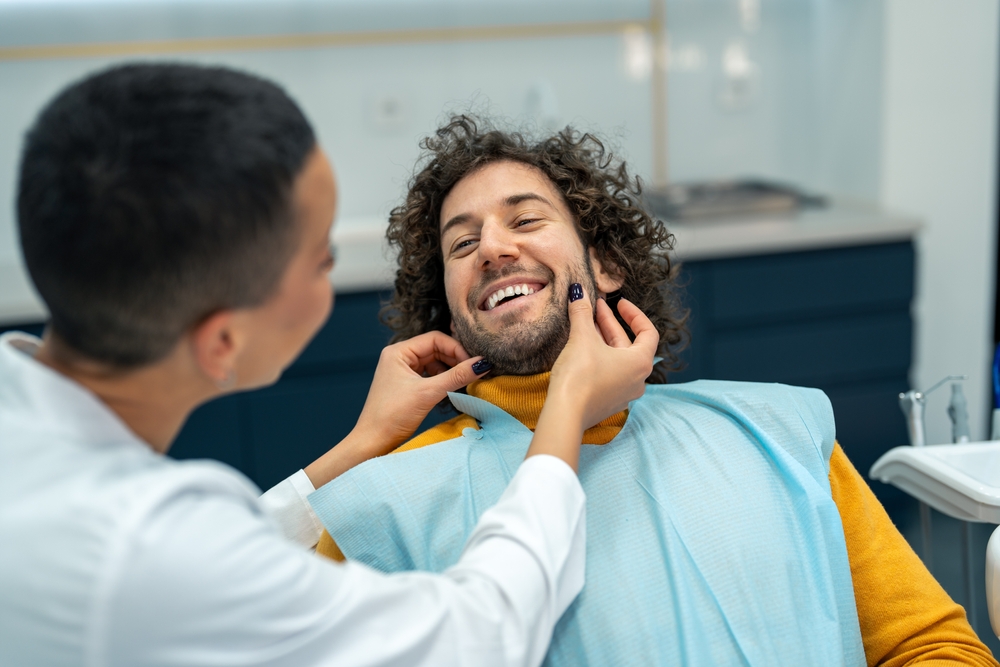 Dentist preparing a smiling male patient for a dental bonding appointment at The Foleck Center, Norfolk, VA 