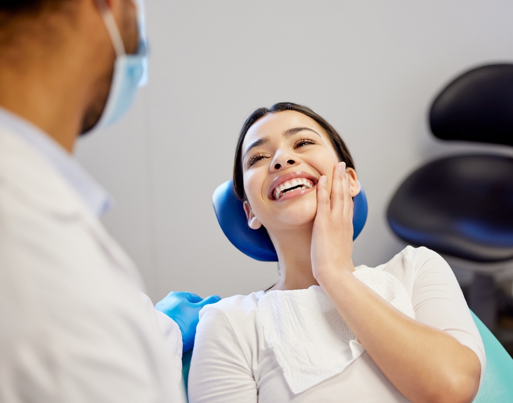 Woman in the dental chair discussing tooth sensitivity concerns with a dentist at The Foleck Center, Virginia Beach, VA 