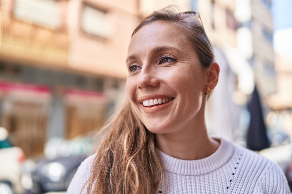 Young blonde woman smiling confident looking to the side at street