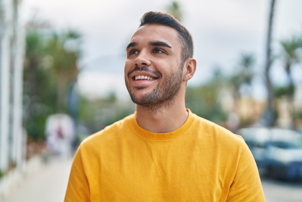 Confident Smile Outdoors: Norfolk Full-Mouth Reconstruction Patient Smiling man outdoors with a confident, healthy smile after full-mouth reconstruction in Norfolk