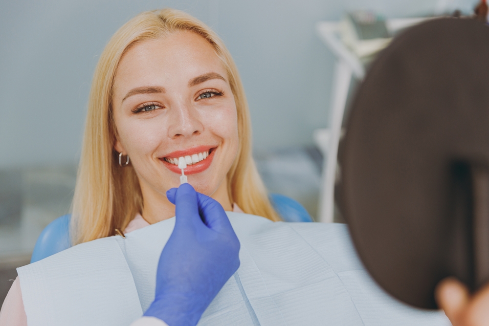 Virginia Beach dental implant patient comparing tooth shade options with her dentist 