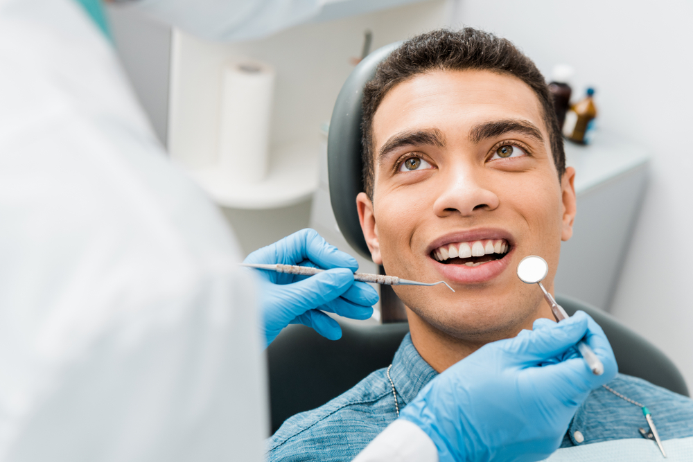 Young male patient smiling during dental exam at The Foleck Center, Virginia Beach sedation dentistry practice serving Hampton Roads