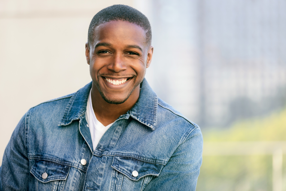 Confident smile after dental care in Virginia Beach, VA, The Foleck Center Smiling man with bright, healthy teeth outdoors, reflecting confidence in dental care at The Foleck Center, Virginia Beach, VA