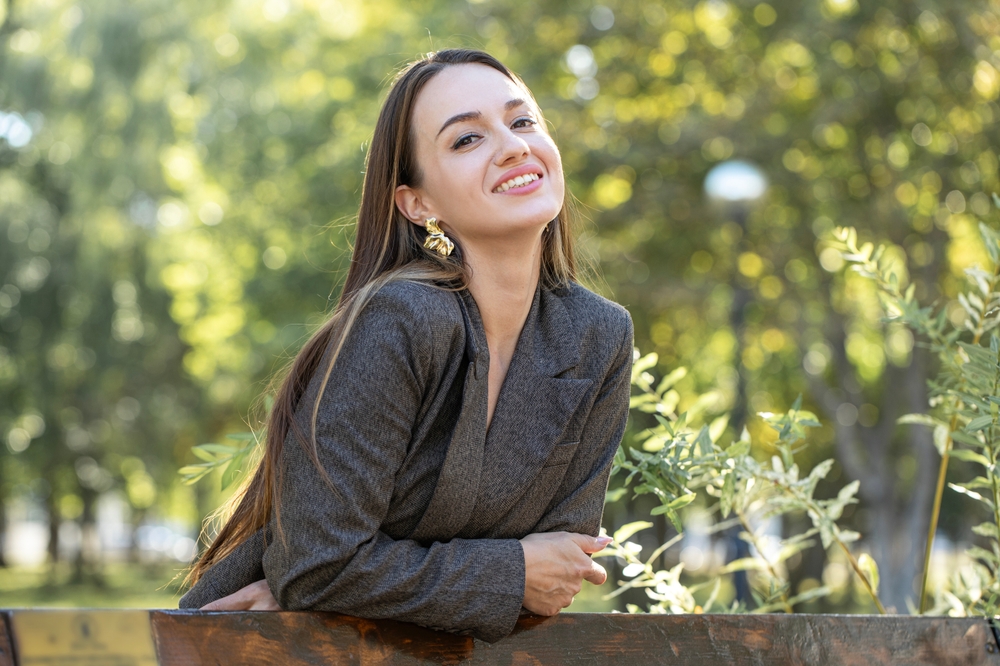 Smiling Patient Outdoors: Hampton Kecoughtan Family Dentistry Smiling woman outdoors, representing a patient of The Foleck Center's family dentistry care in Hampton Kecoughtan