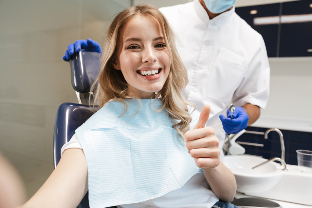 Smile Makeover Visit, Norfolk Dental Office Woman giving a thumbs-up in the dental chair during a smile makeover visit in Norfolk