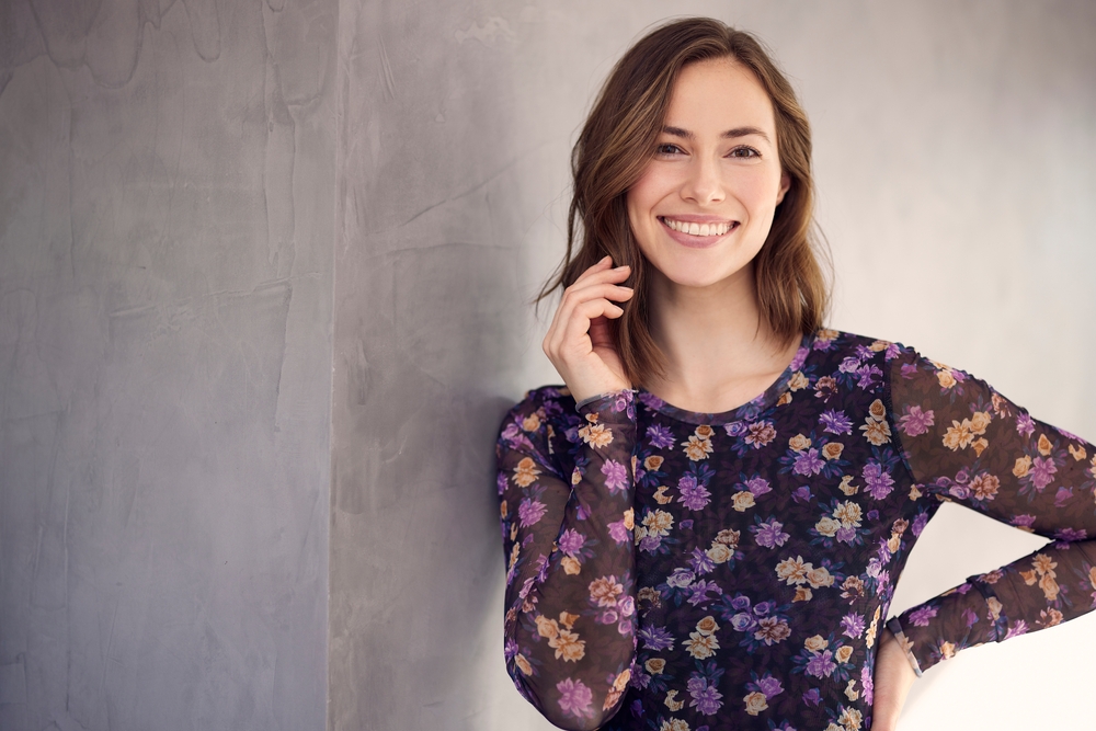 Confident smile: restorative dentistry in the Hampton Roads community Woman smiling confidently in a floral top, representing the healthy smiles achieved through restorative dentistry in the Hampton Roads community