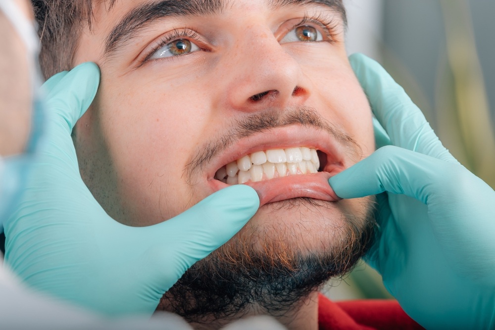 Restorative dental exam: Norfolk dental office Dentist examining a patient's teeth and gums during a restorative dentistry visit at our Norfolk dental office