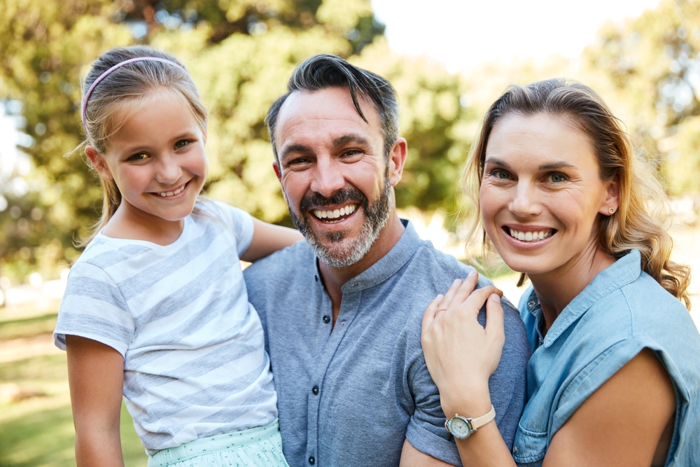 Happy family outdoors in the Norfolk community Family with healthy smiles outdoors in the Norfolk community