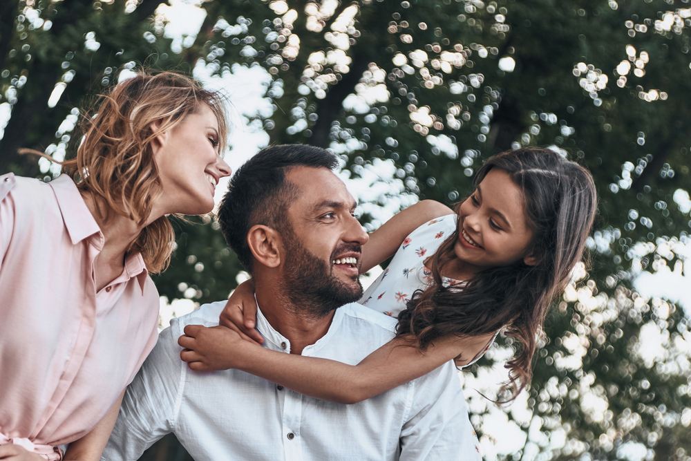 Happy family bonding outdoors in the Norfolk community Family laughing together outdoors in the Norfolk community