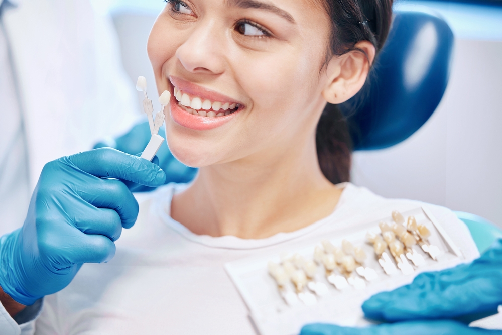 Cosmetic dental consultation at The Foleck Center serving patients in the Suffolk community Dental patient smiling during a shade-matching consultation at The Foleck Center in the Suffolk community