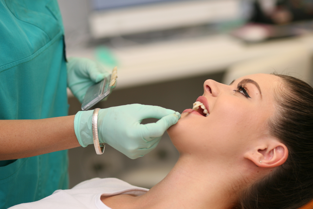 In-house dental lab restorations in Virginia Beach, VA, The Foleck Center Dentist fitting a custom dental restoration on a patient at The Foleck Center in-house dental lab, Virginia Beach, VA