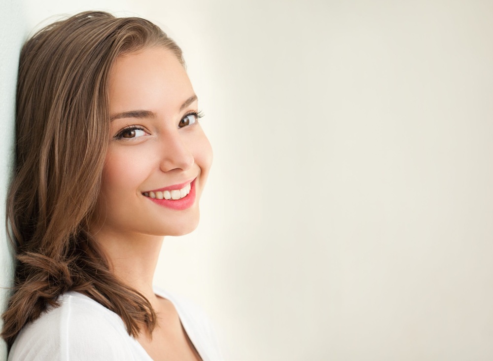 Bright, natural smile: family dentistry in the Norfolk community Woman with a bright, natural smile, representing family dentistry patients in the Norfolk community