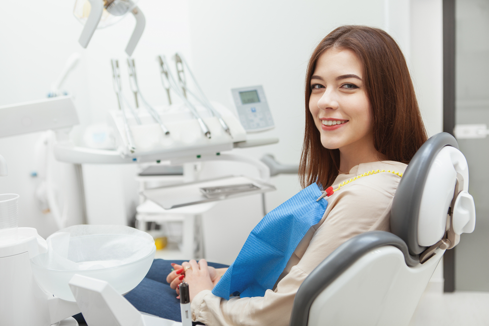 Cosmetic Dentistry Patient: Virginia Beach Dental Chair Visit Smiling woman seated in a dental chair before a cosmetic dentistry visit in Virginia Beach