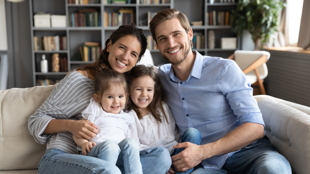 Family relaxing together on the couch at home, reflecting the well-being restored by treating sleep apnea in Hampton 